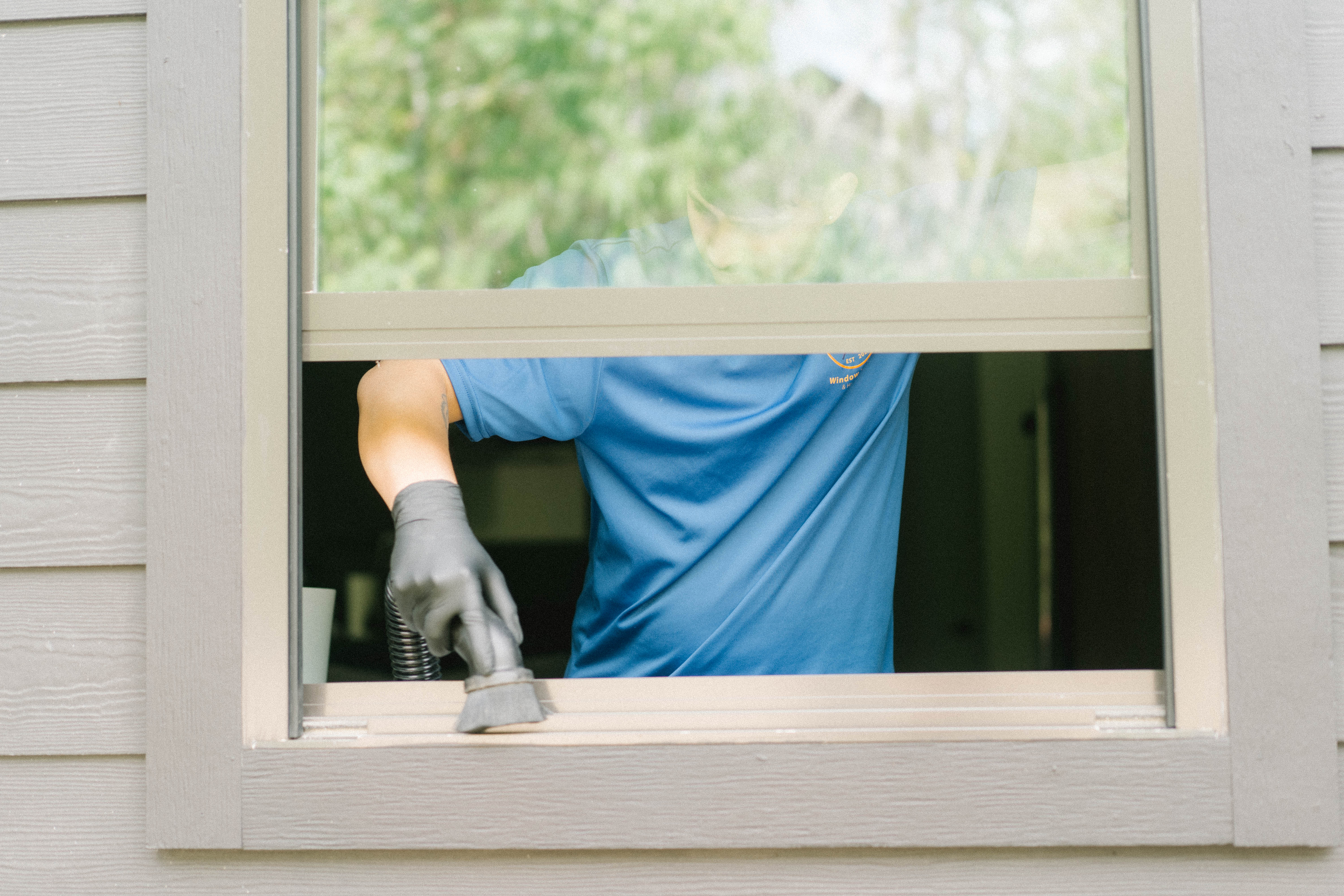 Technician vacuuming a window track